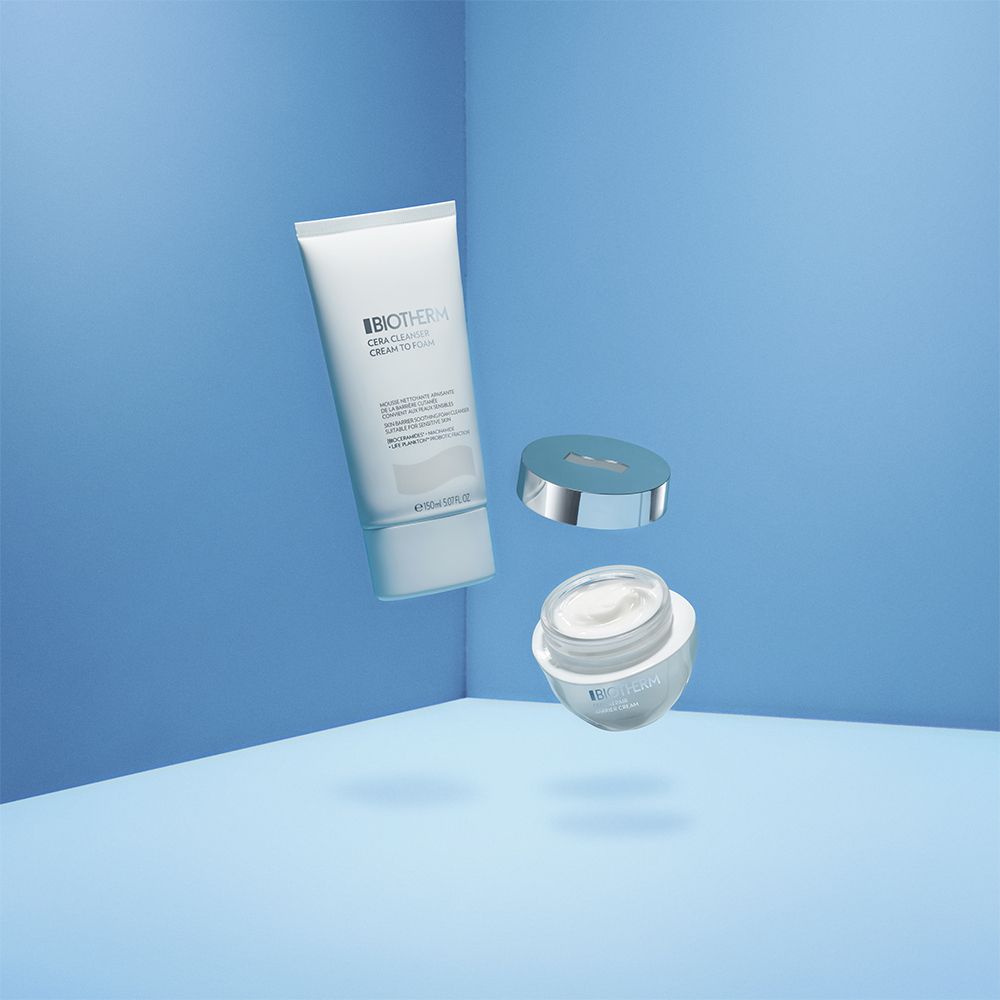 Set di prodotti: tubo e vasetto BIOTHERM Cera Cleanser. Disposizione fluttuante su sfondo blu.