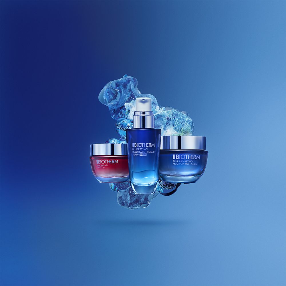 Tre prodotti BIOTHERM su sfondo blu. Crema, siero e altra crema.