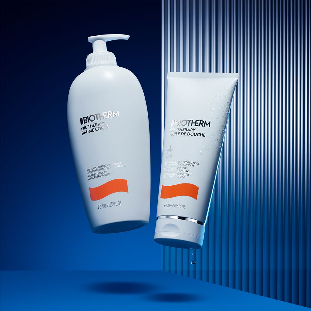 Due prodotti: flacone e tubo. Testo: BIOTHERM OIL THERAPY. Sfondo blu.