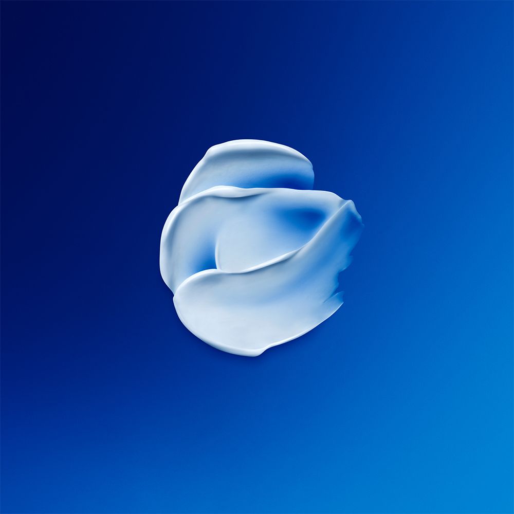 Prodotto in crema bianco su sfondo blu. Texture cremosa.