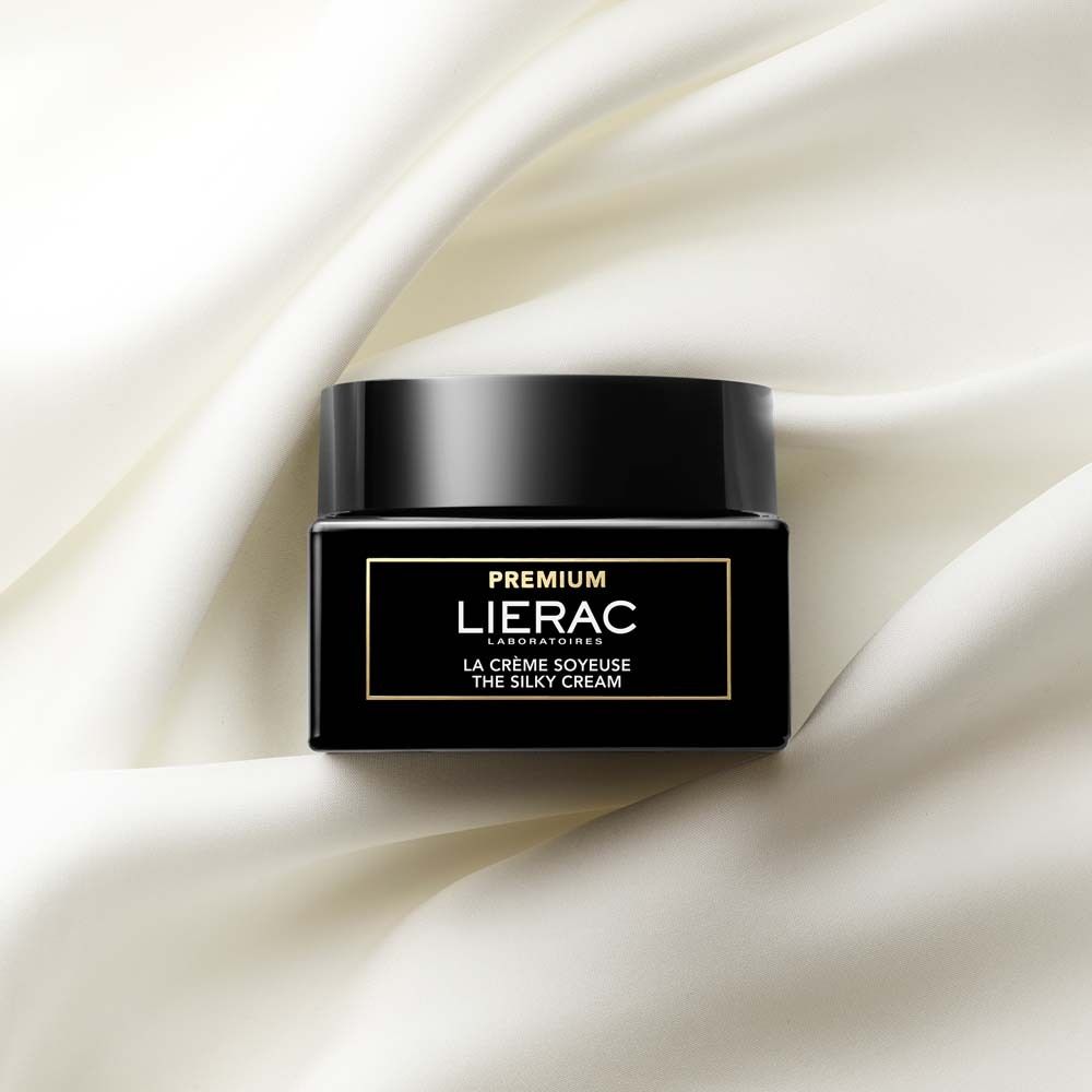 Vaso nero su tessuto bianco. Scritta: PREMIUM, LIERAC, LA CRÈME SOYEUSE, THE SILKY CREAM.