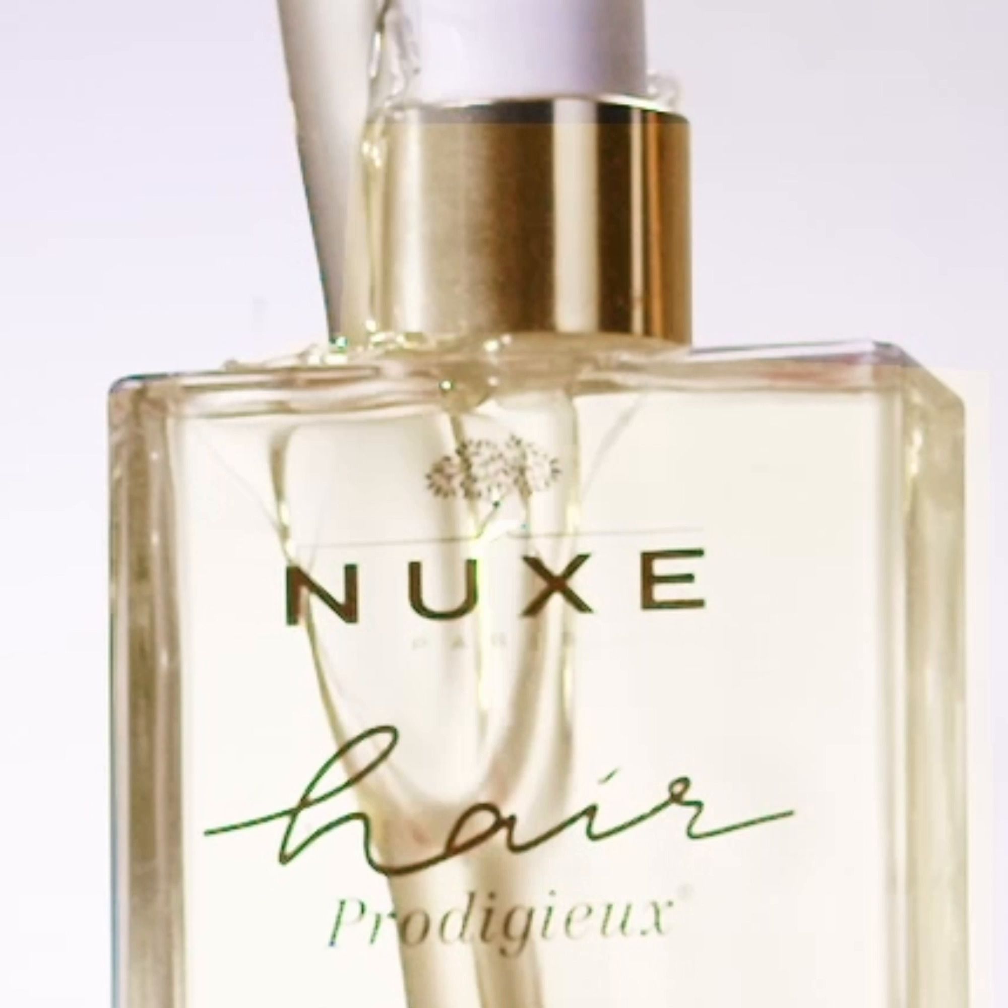 Primo piano della Maschera Pre-Shampoo NUXE Hair Prodigieux. Tappo dorato, nome del prodotto e logo.