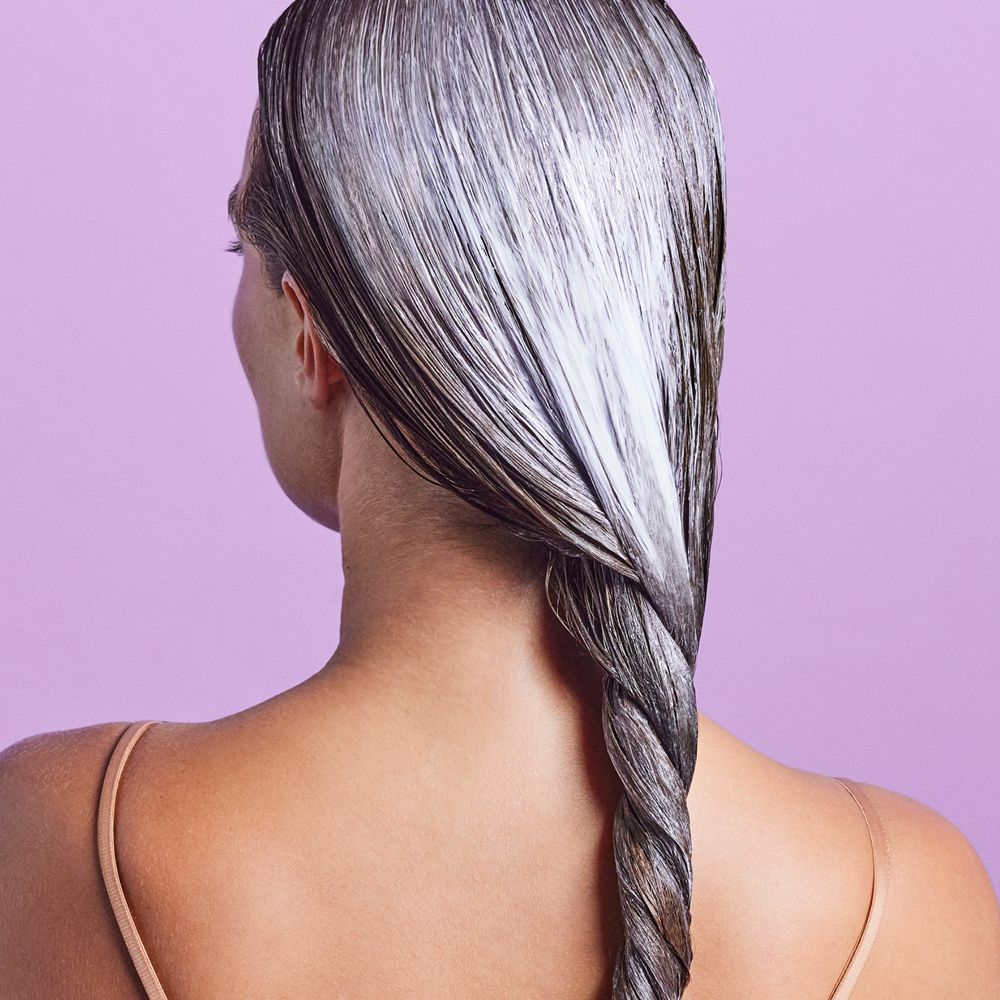 Vista posteriore di una persona con capelli intrecciati trattati con balsamo.