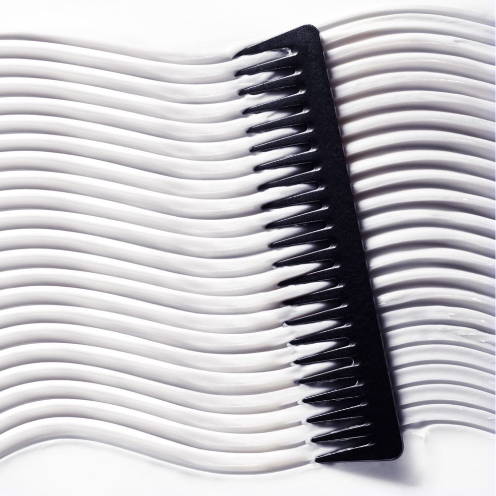 Pettine nero su balsamo bianco ondulato.