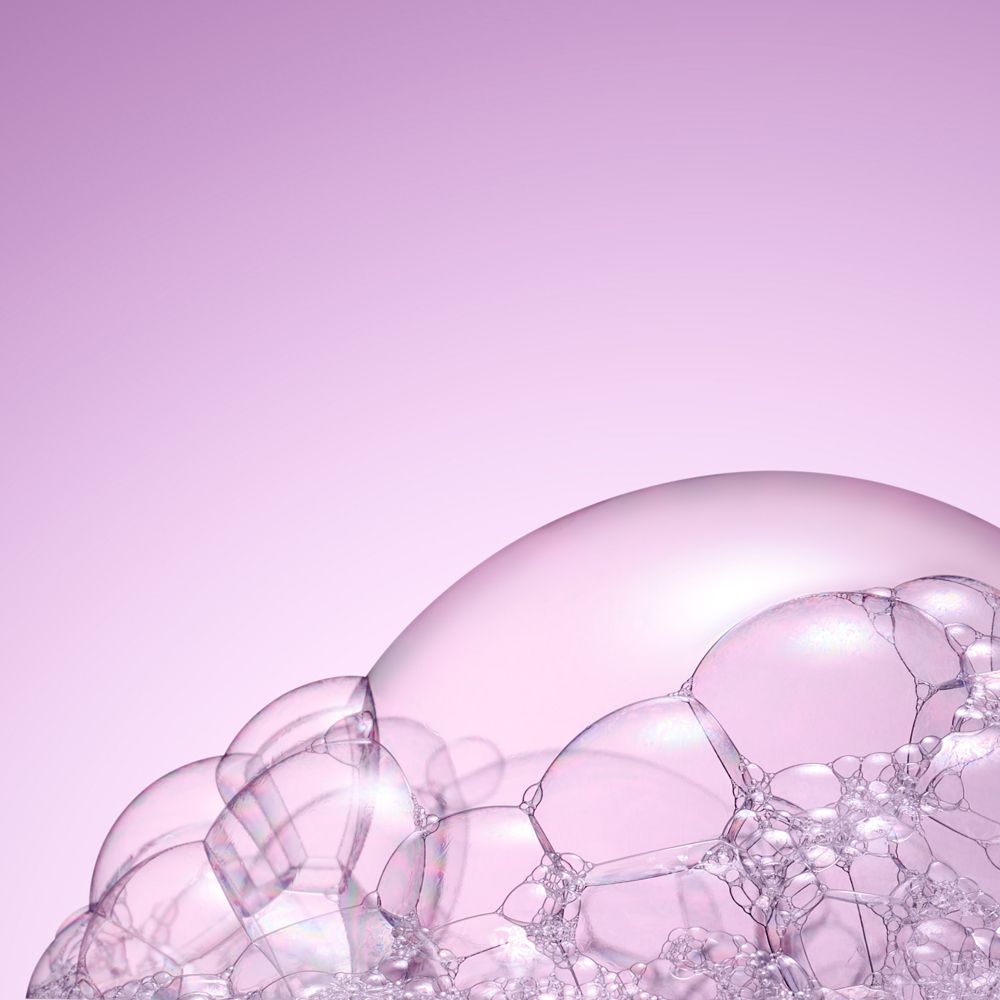 Primo piano di bolle di sapone. Sfondo rosa.