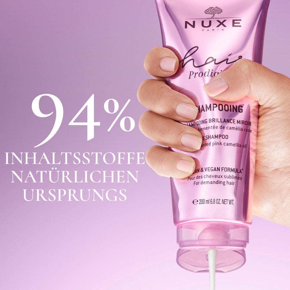 Mano che tiene un tubetto di shampoo. Testo: 94% ingredienti di origine naturale.