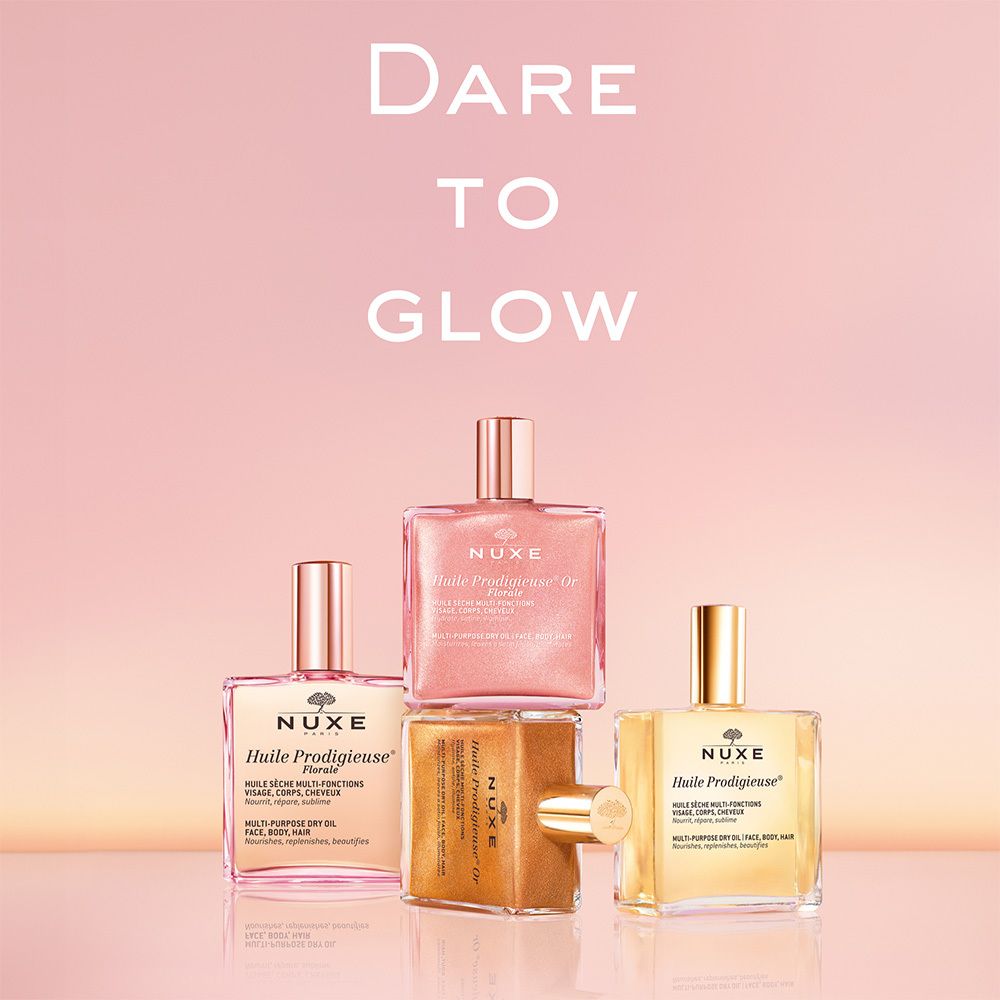 Quattro flaconi Nuxe Huile Prodigieuse® Or Florale. Flaconi rosa e dorati. Testo.