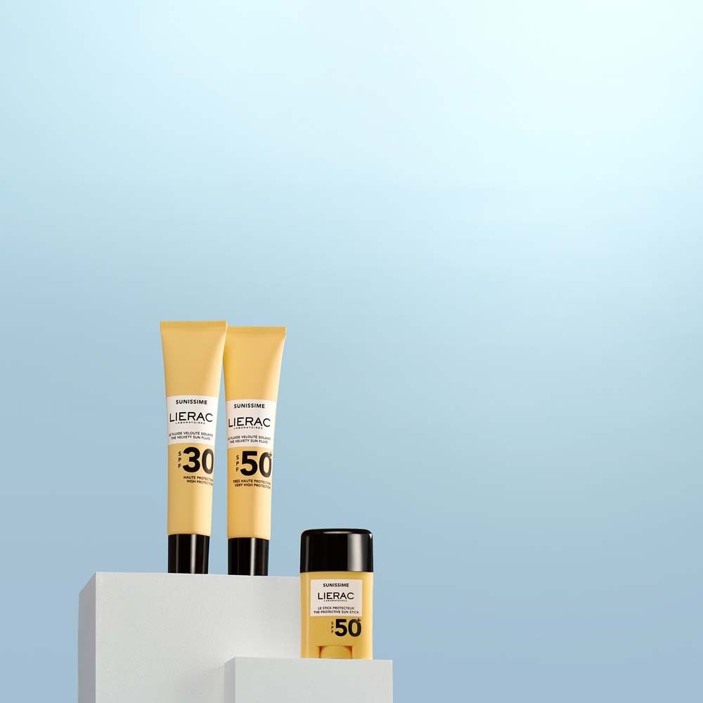 Tre prodotti solari su piedistallo bianco. Due tubi e un flacone. Scritta: LIERAC, SPF 30 e 50.