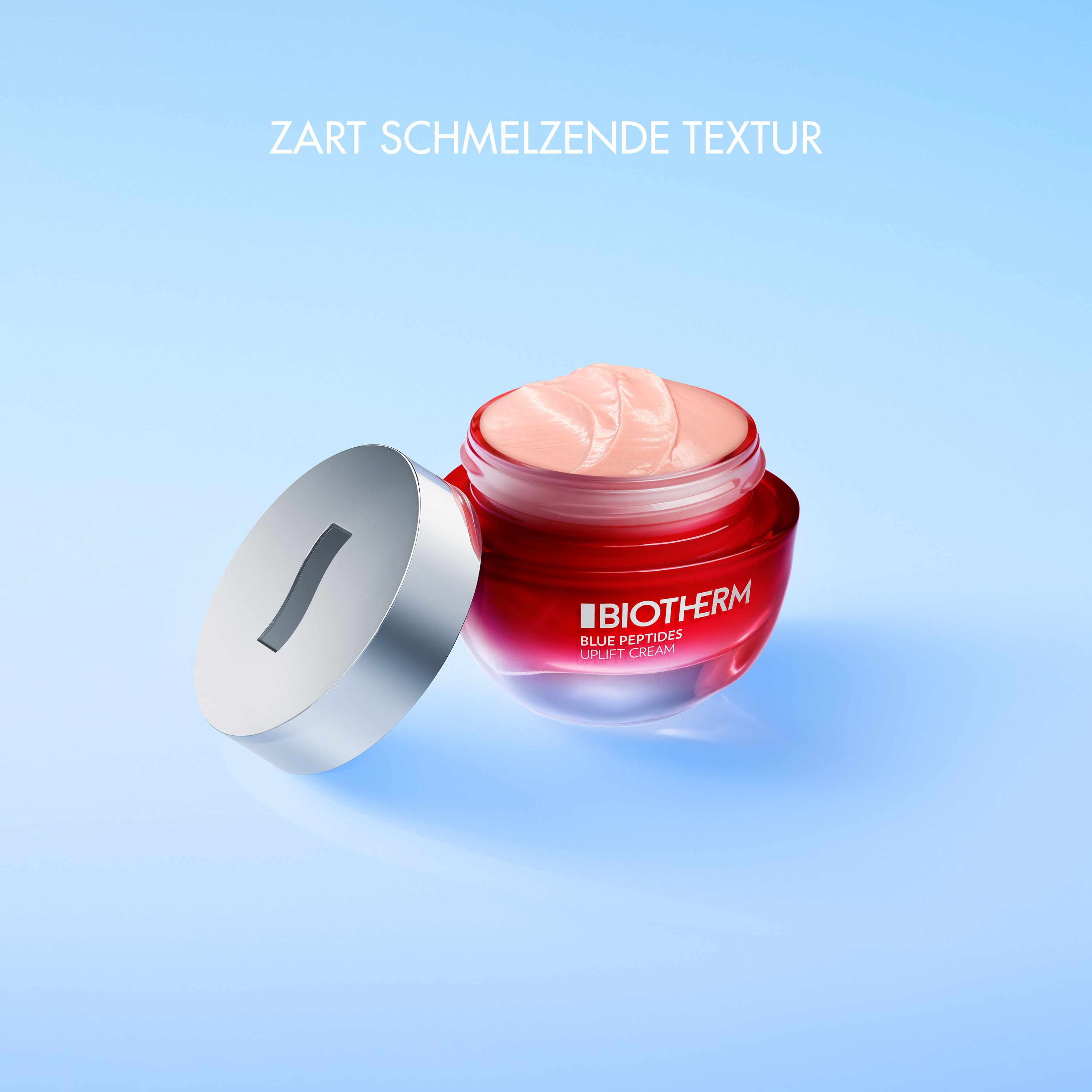 Vasetto rosso aperto con coperchio argentato. Crema visibile. Testo: ZART SCHMELZENDE TEXTUR.