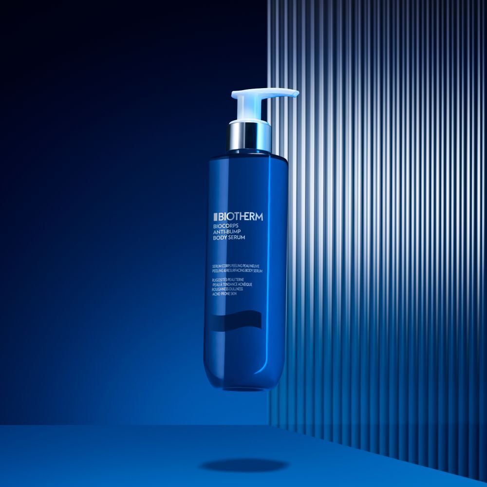 Siero corpo Biotherm Biocorps, flacone blu con dosatore, su sfondo blu.