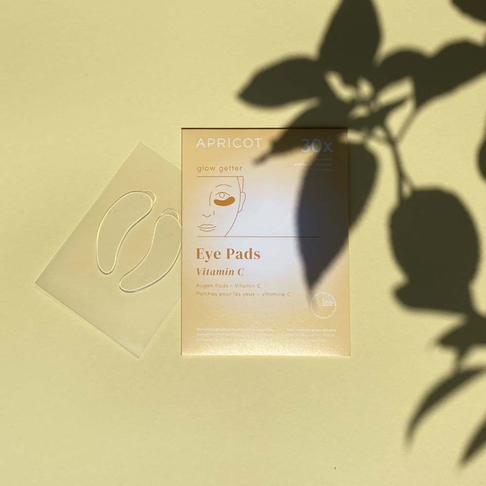 Confezione di cuscinetti per gli occhi e due cuscinetti accanto. Stampato: APRICOT, Eye Pads Vitamin C.