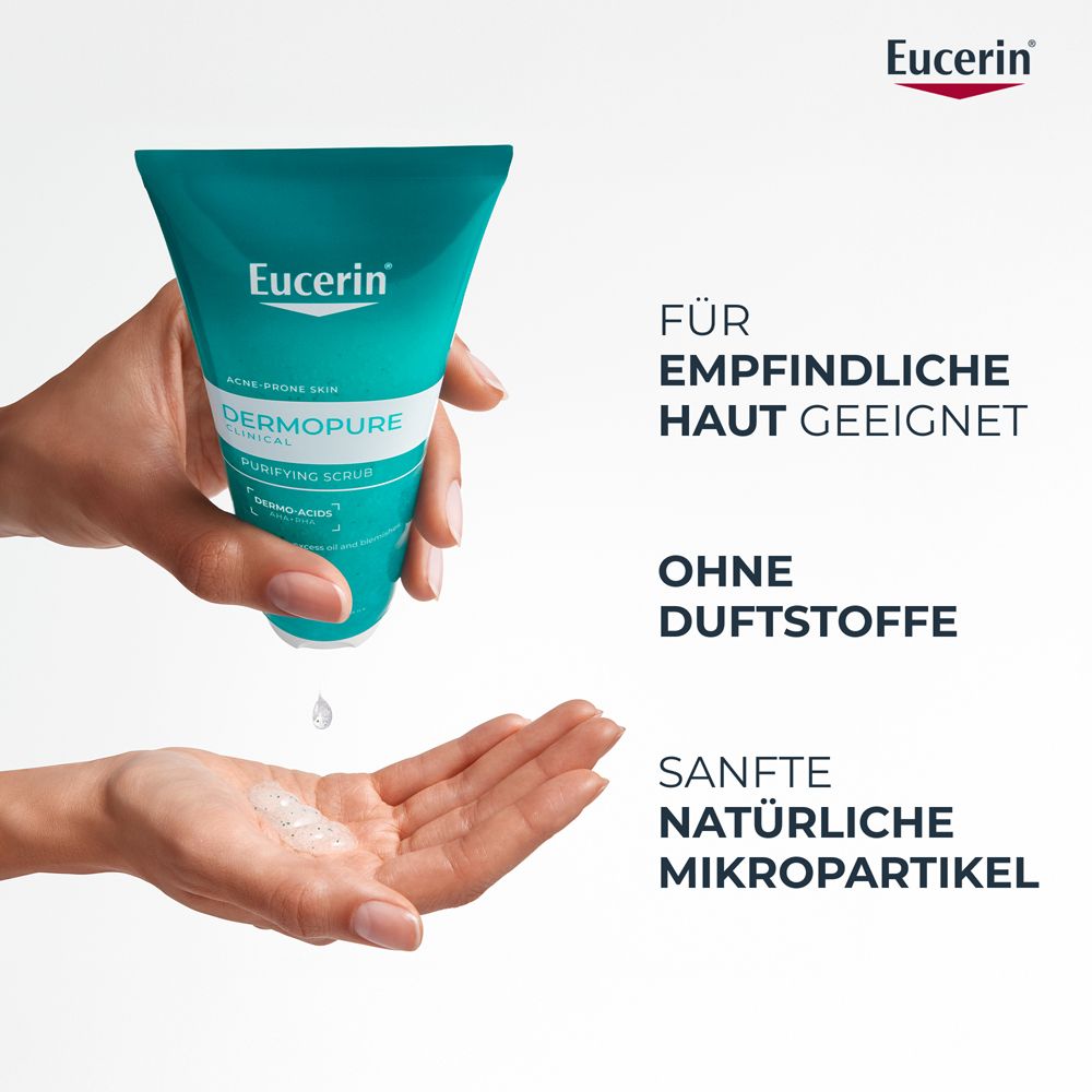 Scrub purificante Eucerin Dermopure in una mano, microparticelle delicate cadono nell'altra mano.