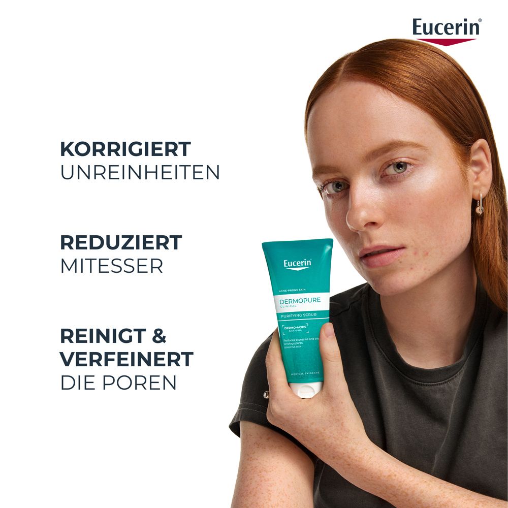Gel esfoliante Eucerin Dermopure in tubo verde con tappo bianco, tenuto da una donna con capelli rossi.
