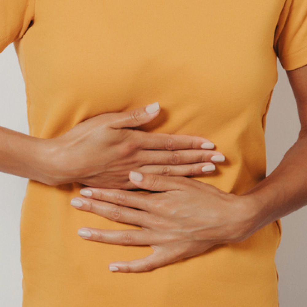 Persona con le mani sullo stomaco. Maglietta gialla.