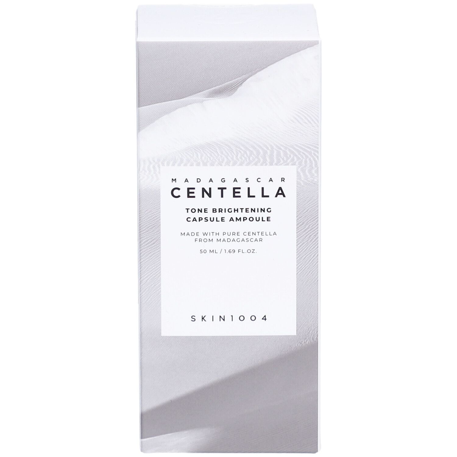 Confezione bianca con informazioni sul prodotto. Testo: MADAGASCAR CENTELLA Tone Brightening Capsule Ampoule. Logo SKIN1004.