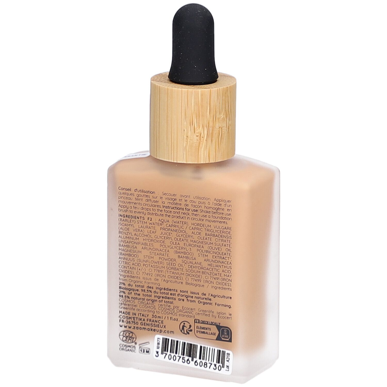 Retro di un flacone quadrato di vetro con tappo in bambù e contagocce. Scritte: ingredienti, istruzioni per l'uso. Informazioni sul prodotto.