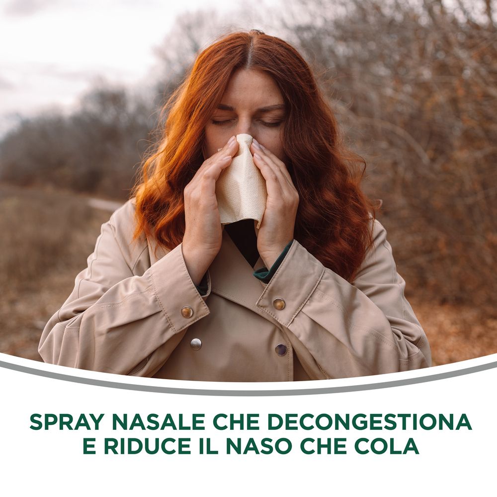 Donna con fazzoletto. Testo: Spray Nasale che decongestiona e riduce il naso che cola. Sfondo: alberi sfocati.