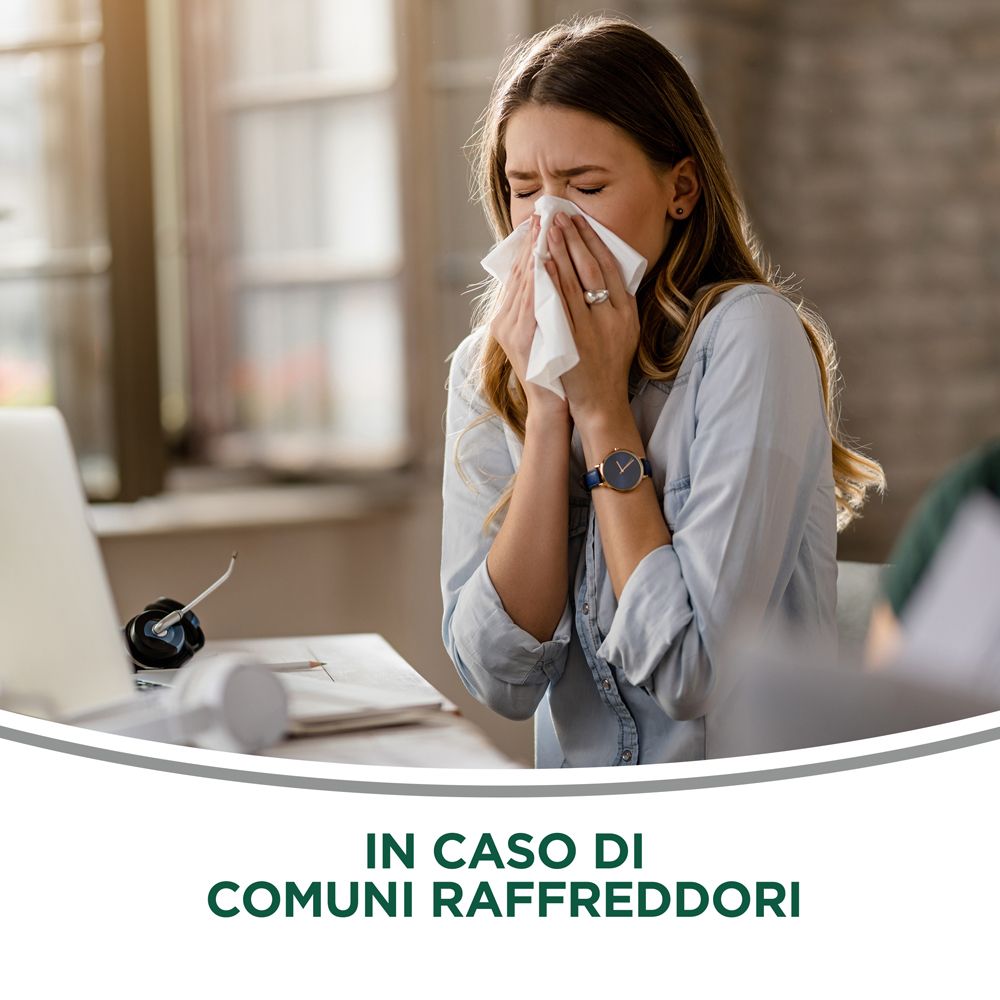 Donna con fazzoletto. Testo: In caso di raffreddori comuni. Sfondo: ufficio con laptop e penna.