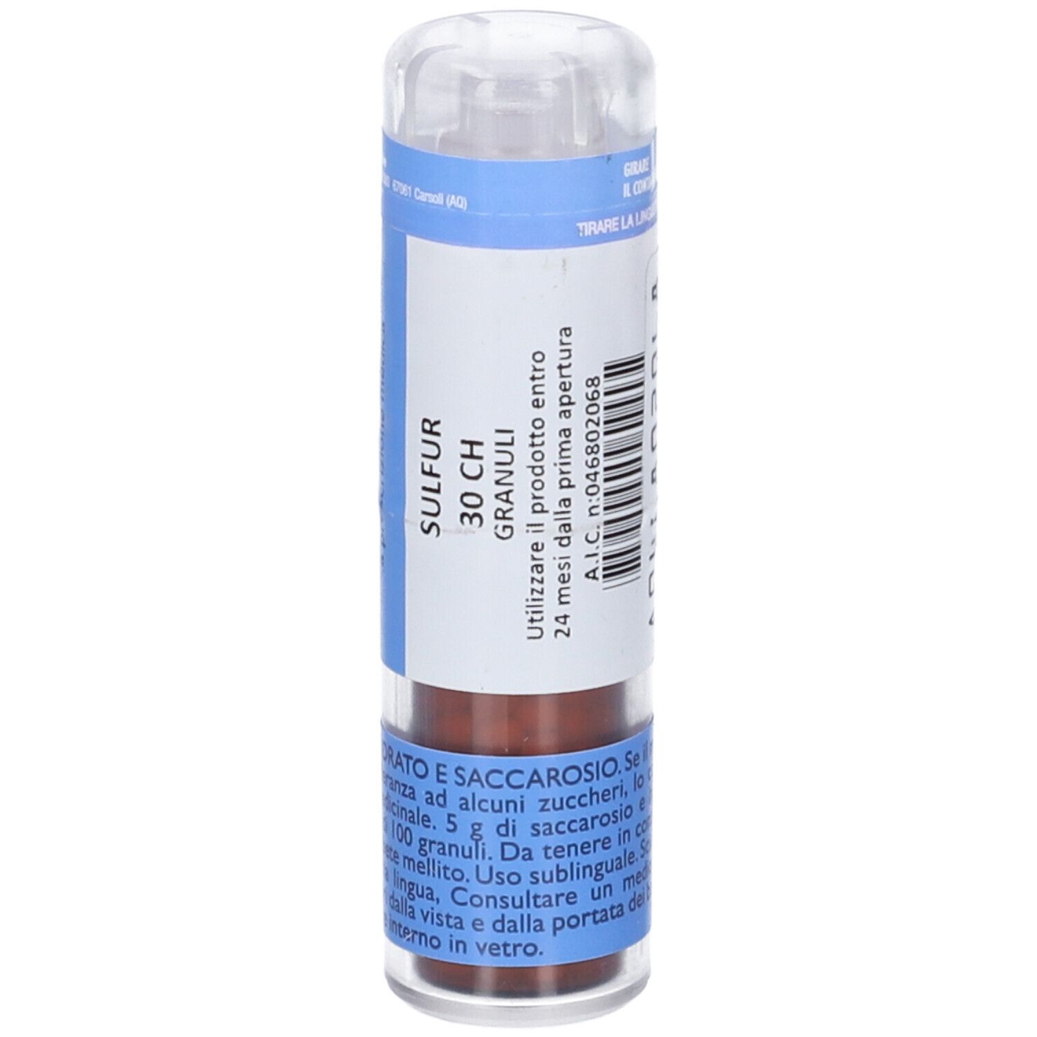 Flacone cilindrico multidose. Etichetta blu e bianca con testo. Tappo trasparente. Granuli marroni visibili.