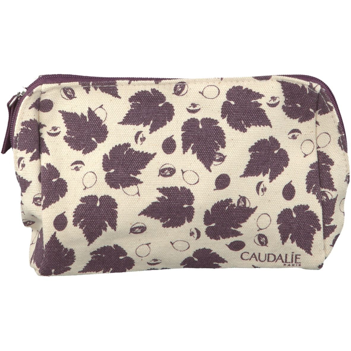Pochette trucco Caudalie con motivo a foglie. Base beige, foglie viola. Chiusura zip, logo in basso a destra.