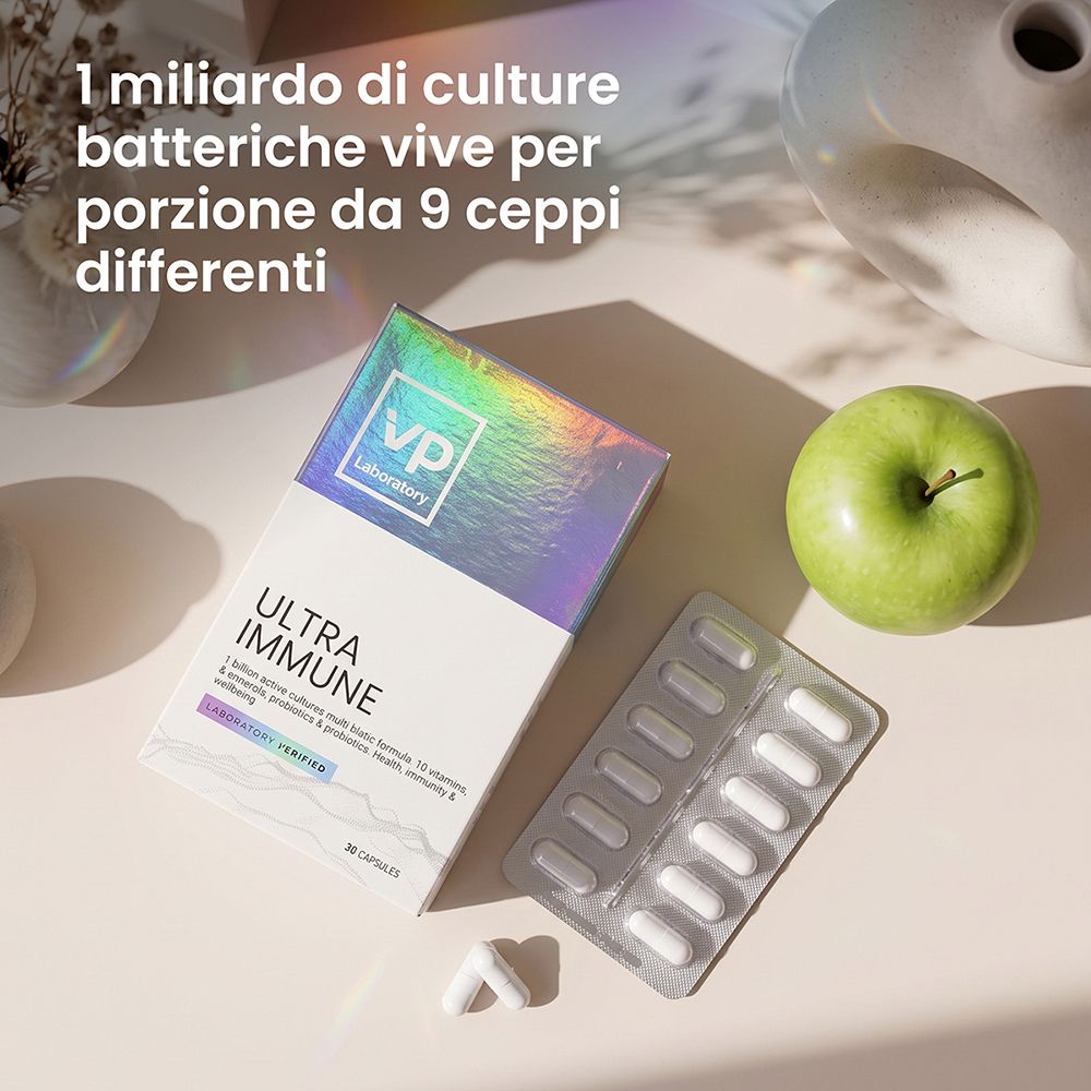 Confezione e blister con capsule. Una mela verde accanto.