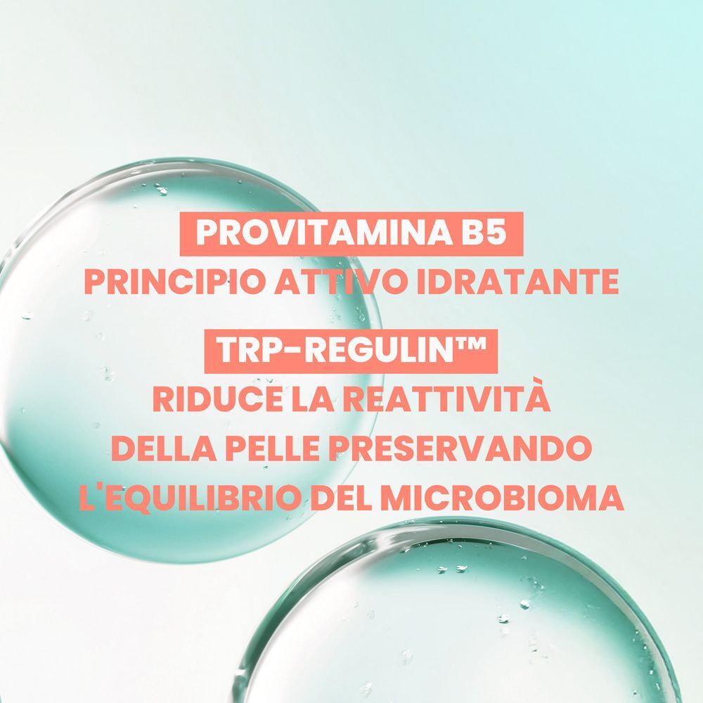 Primo piano di gocce d'acqua. Testo in italiano: 'Provitamina B5, principio attivo idratante. TRP-REGULIN™, riduce la reattività della pelle'.