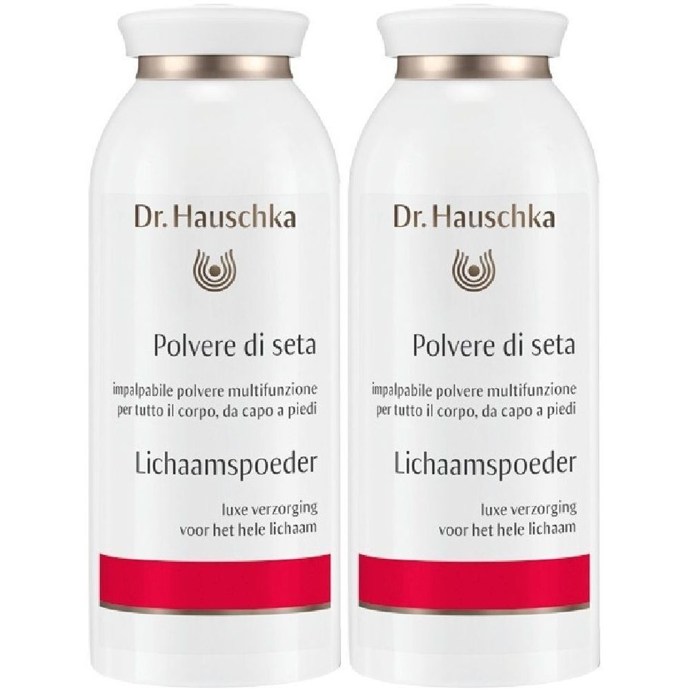 Due flaconi bianchi con fascia rossa. Scritta: Dr. Hauschka, Polvere di seta, Lichaamspoeder.