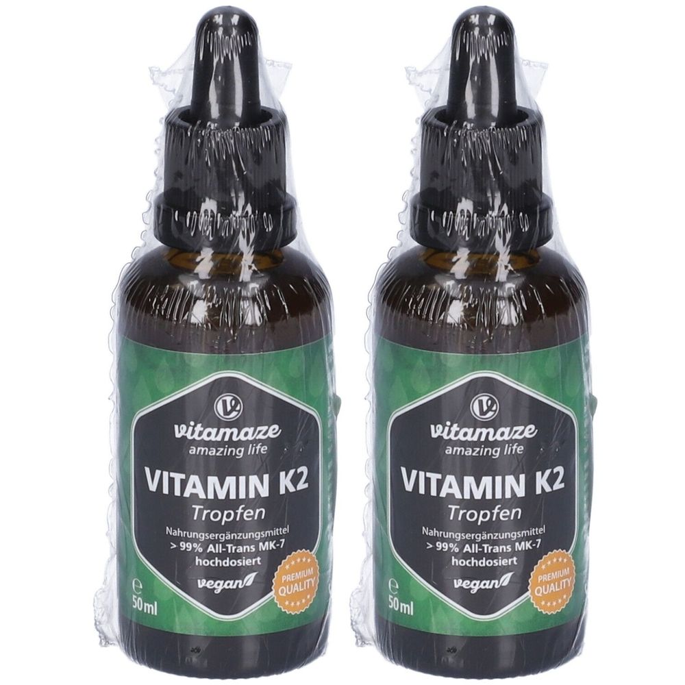 Due flaconi contagocce. Scritta: Vitamina K2 gocce, vitamaze, vegan. Flaconi in vetro marrone con tappo nero, confezionati in pellicola.