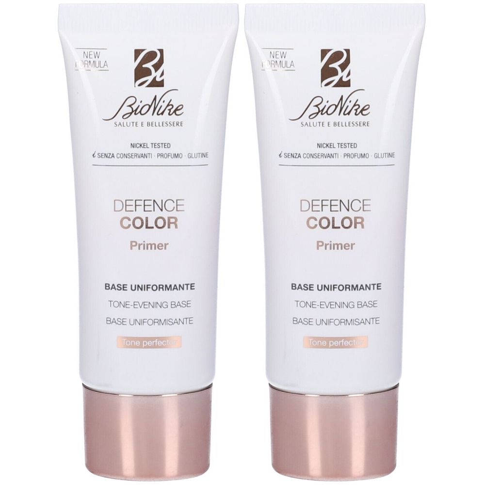 Due tubi di Bionike Defence Color Primer. Bianchi, con base color oro rosa. Scritta: Defence Color Primer, Base Uniformante.