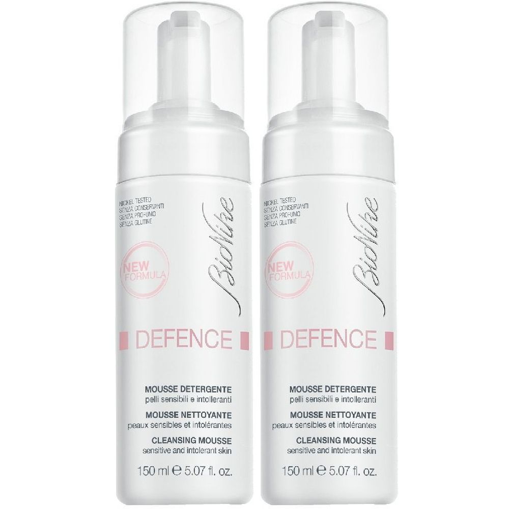 Due flaconi bianchi con erogatore spray. Scritta: BioNike Defence Mousse Detergente. Etichetta rosa con "NEW FORMULA".