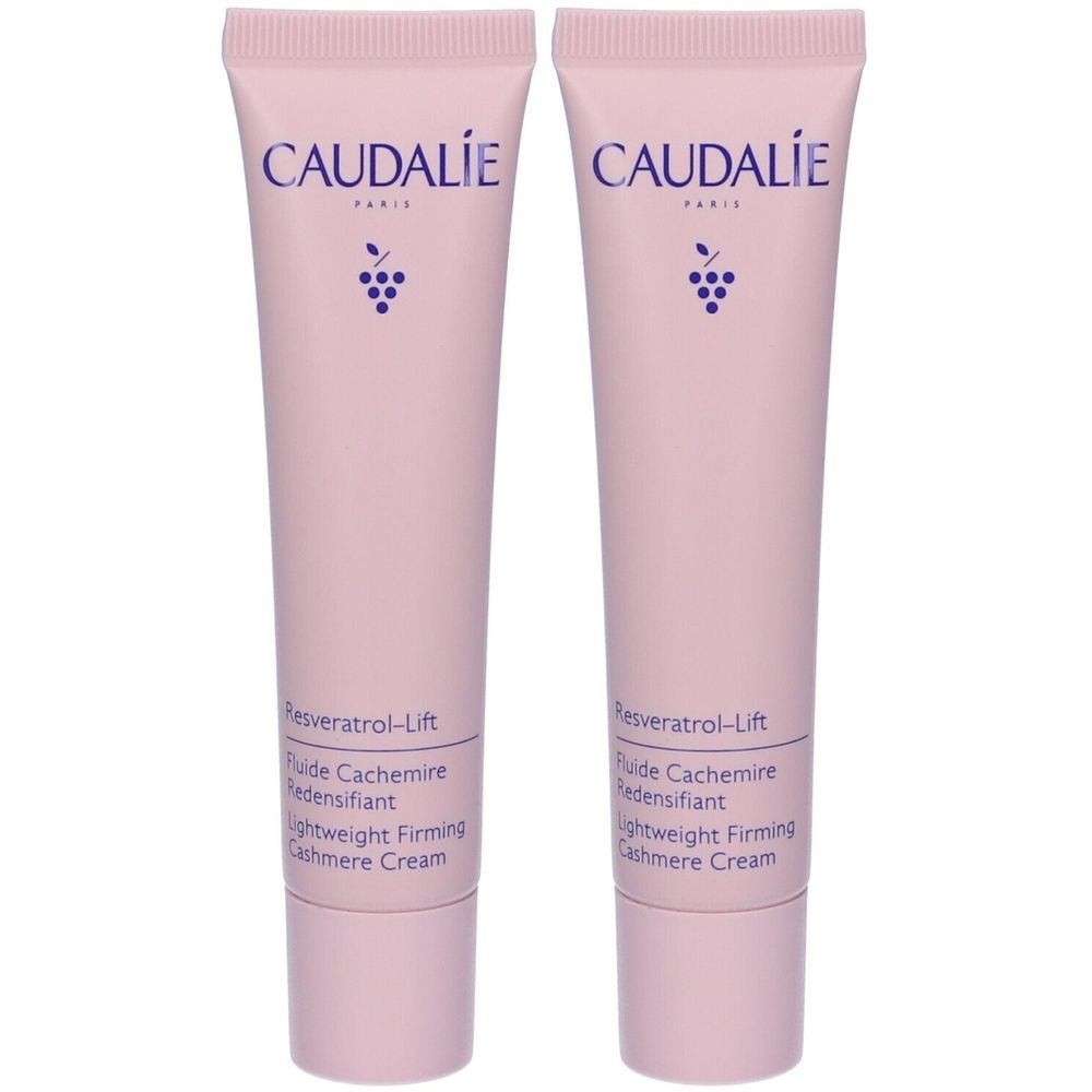 Due tubi di crema rosa. Scritta: CAUDALIE, Resveratrol-Lift, Fluide Cachemire Redensifiant, Lightweight Firming Cashmere Cream. Testo viola.