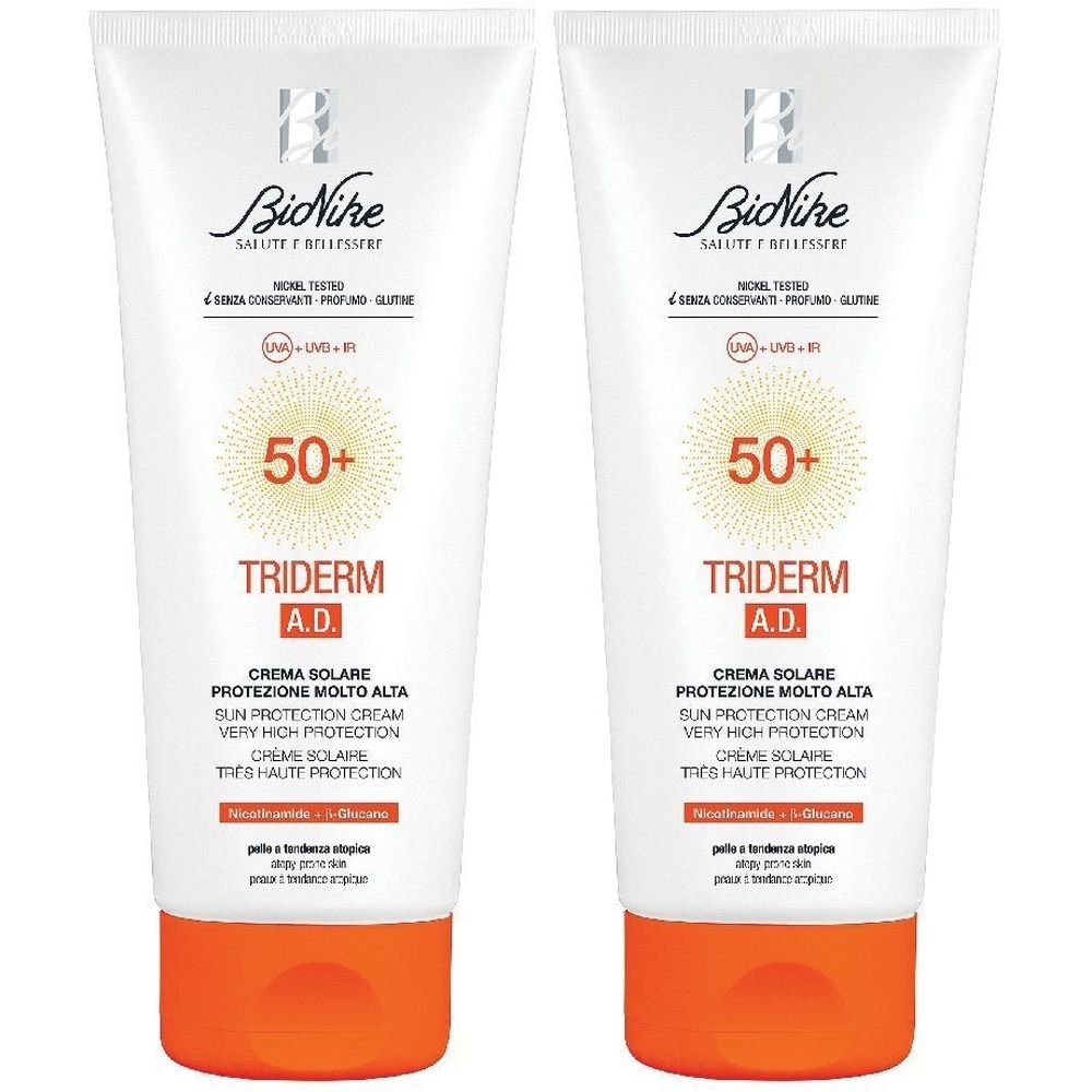 Due tubi di crema solare. Bianchi, con tappo arancione. Scritta: Triderm A.D. 50+.