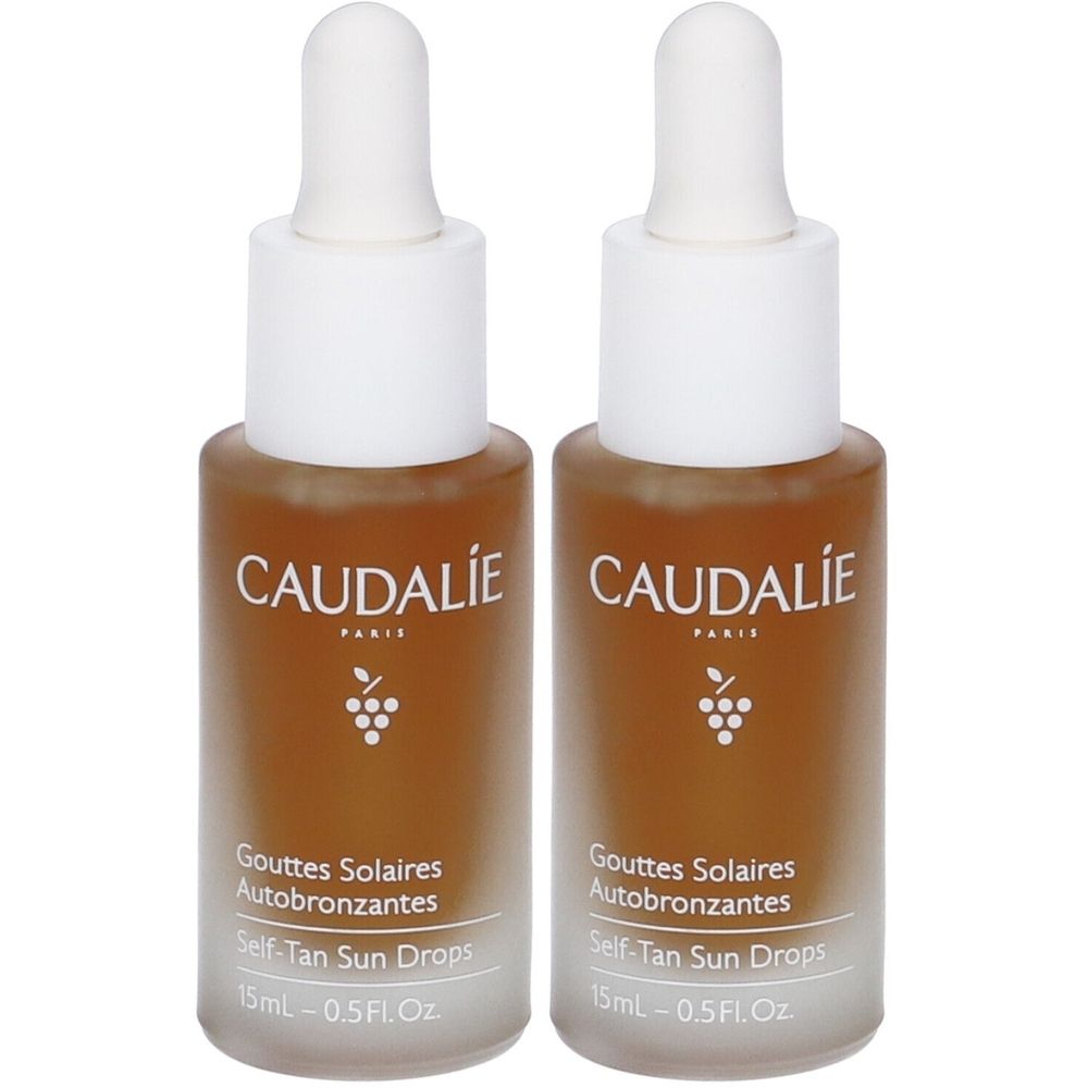 Due flaconi con tappi bianchi e liquido marrone. Scritta: CAUDALIE, Gouttes Solaires Autobronzantes, Self-Tan Sun Drops, 15ml.