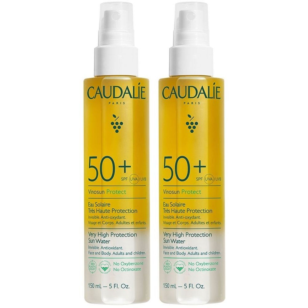 Due flaconi spray con liquido giallo. Scritta: Caudalie, 50+ SPF, protezione solare. Per viso e corpo. 150 ml.