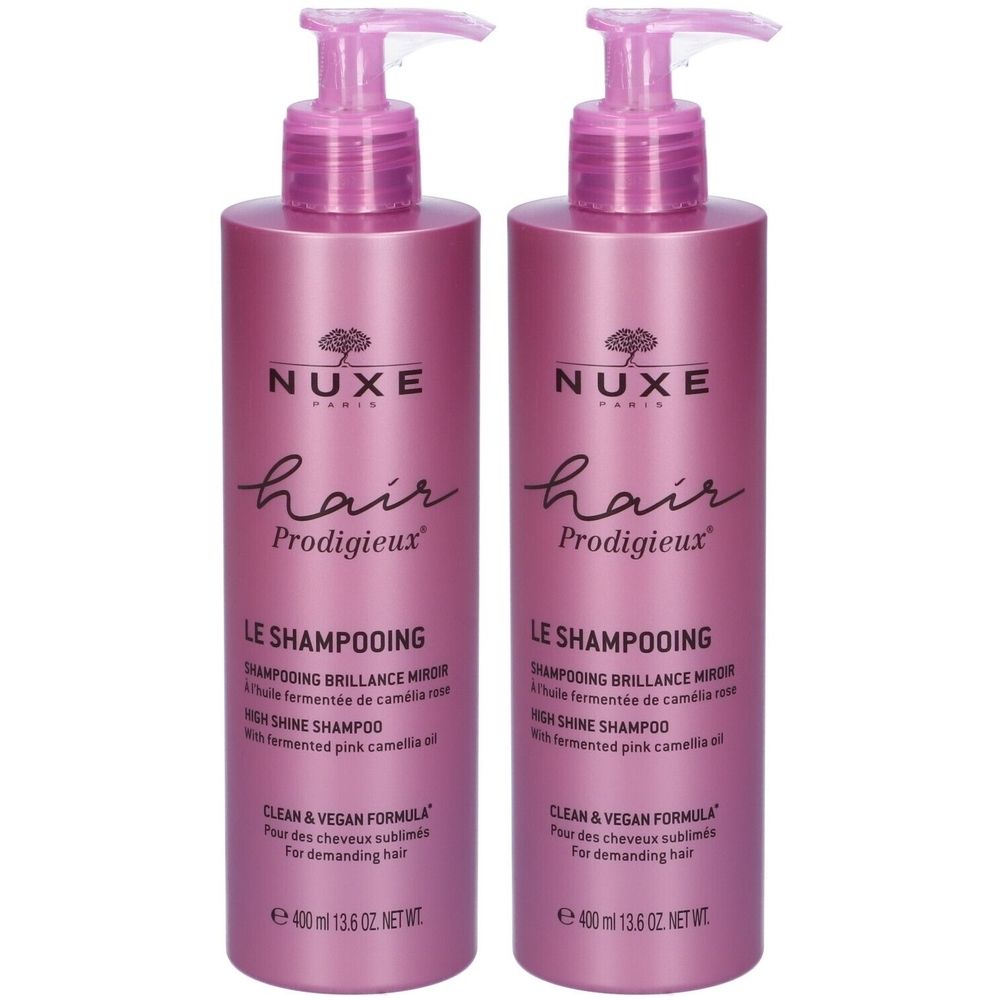 Due flaconi di shampoo Nuxe Hair Prodigieux. Flaconi rosa con dosatore a pompa. Testo: Le Shampooing, Hair Prodigieux, Clean & Vegan Formula.