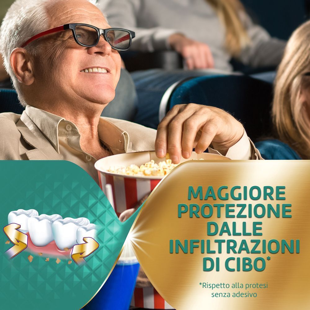 Uomo anziano al cinema. Testo: MAGGIORE PROTEZIONE DALLE INFILTRAZIONI DI CIBO. Grafica: protesi dentaria con frecce.