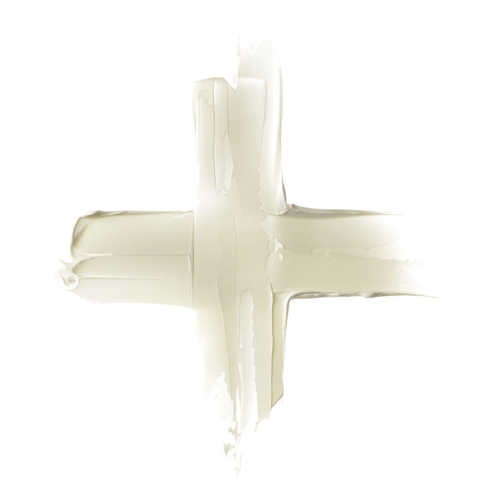 Tracce di crema a forma di croce. Colore beige chiaro. Su sfondo bianco.