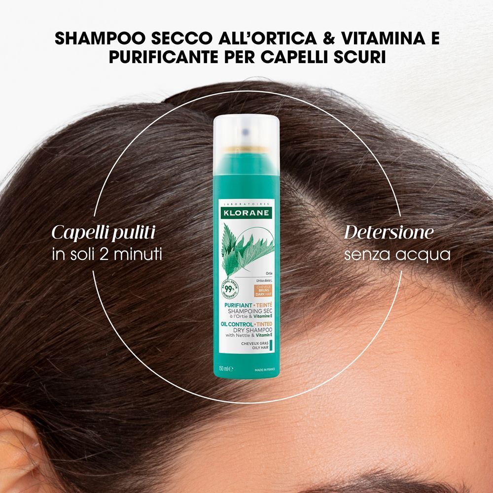 Prodotto su cuoio capelluto. Scritta: Klorane, Shampoo secco all'ortica e Vitamina E. Per capelli scuri. Detergenza senza acqua.