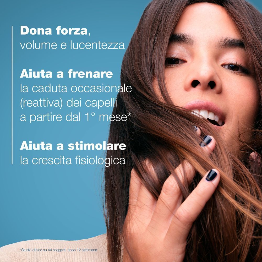 Una donna con lunghi capelli castani. Testo: Dona forza, volume e lucentezza. Aiuta a frenare la caduta occasionale dei capelli. Aiuta a stimolare la crescita fisiologica.