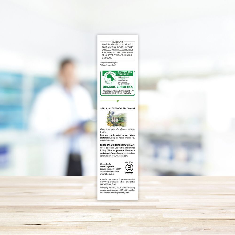 Retro della confezione di gel di aloe vera. Testo e loghi, tra cui Organic Cosmetics. Sfondo: farmacia.
