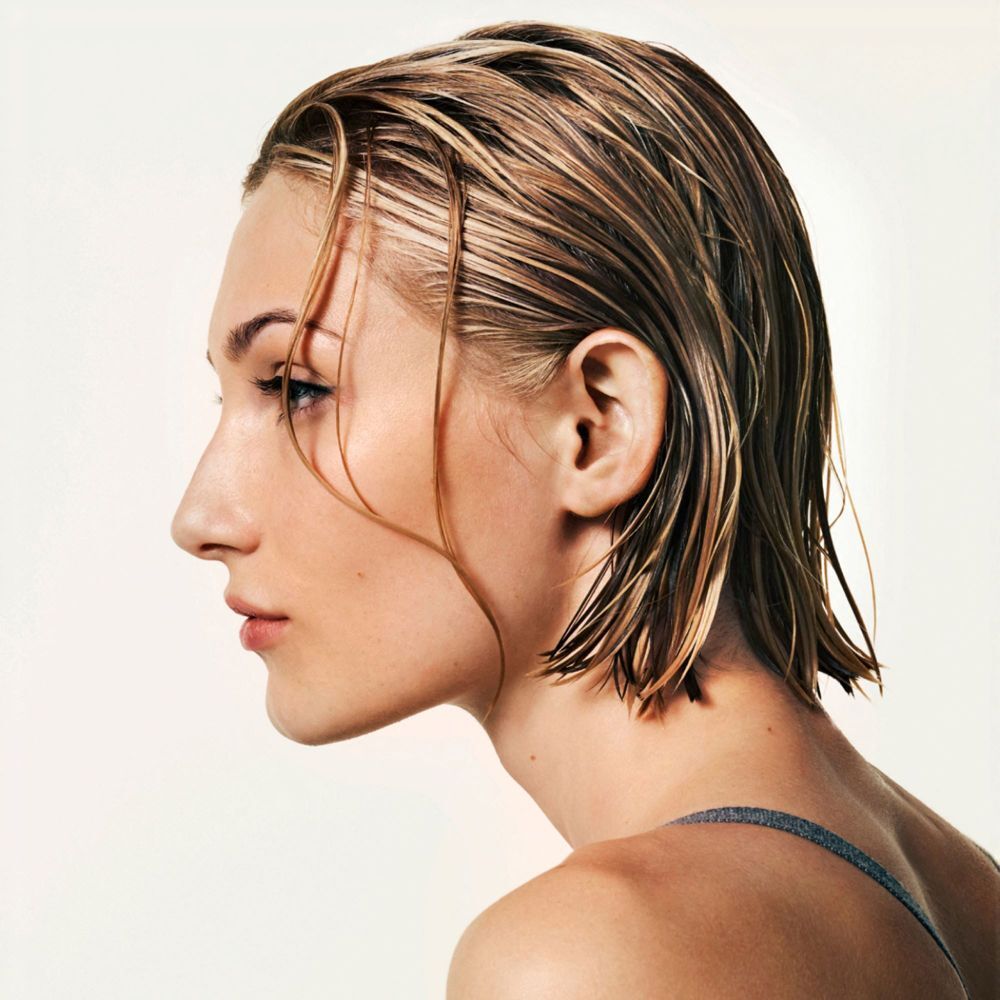 Vista di profilo di una donna con capelli bagnati e pettinati all'indietro.