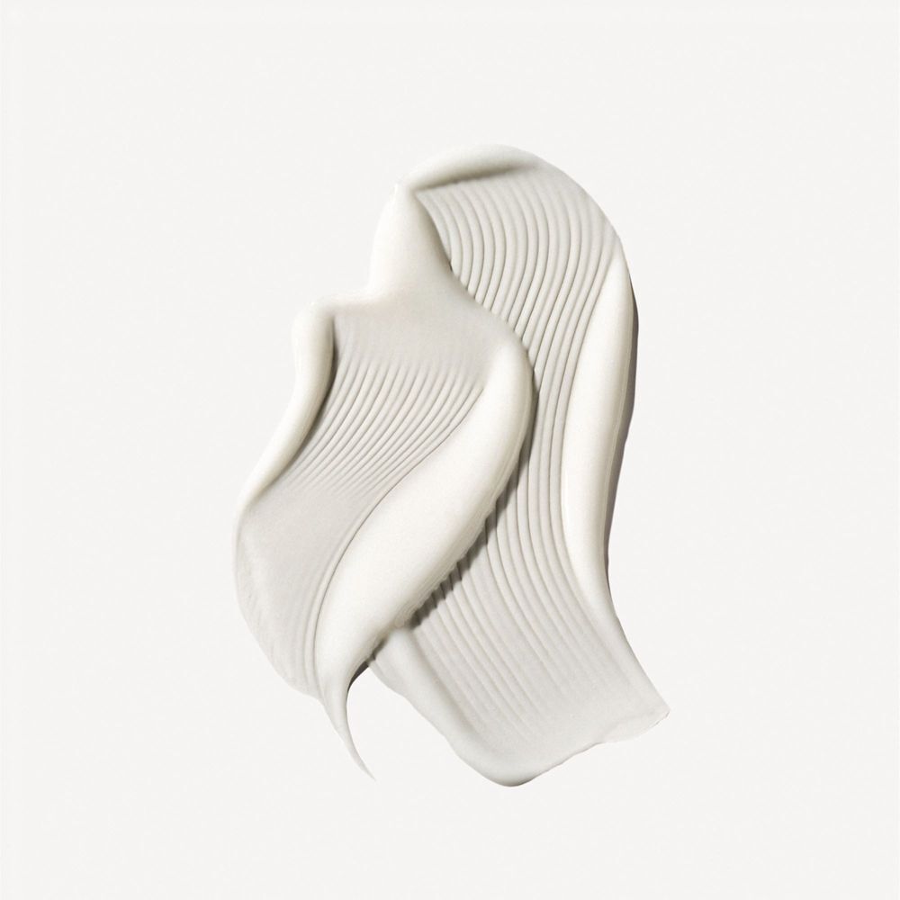 Una texture di crema bianca con sottili scanalature, distribuita su una superficie.