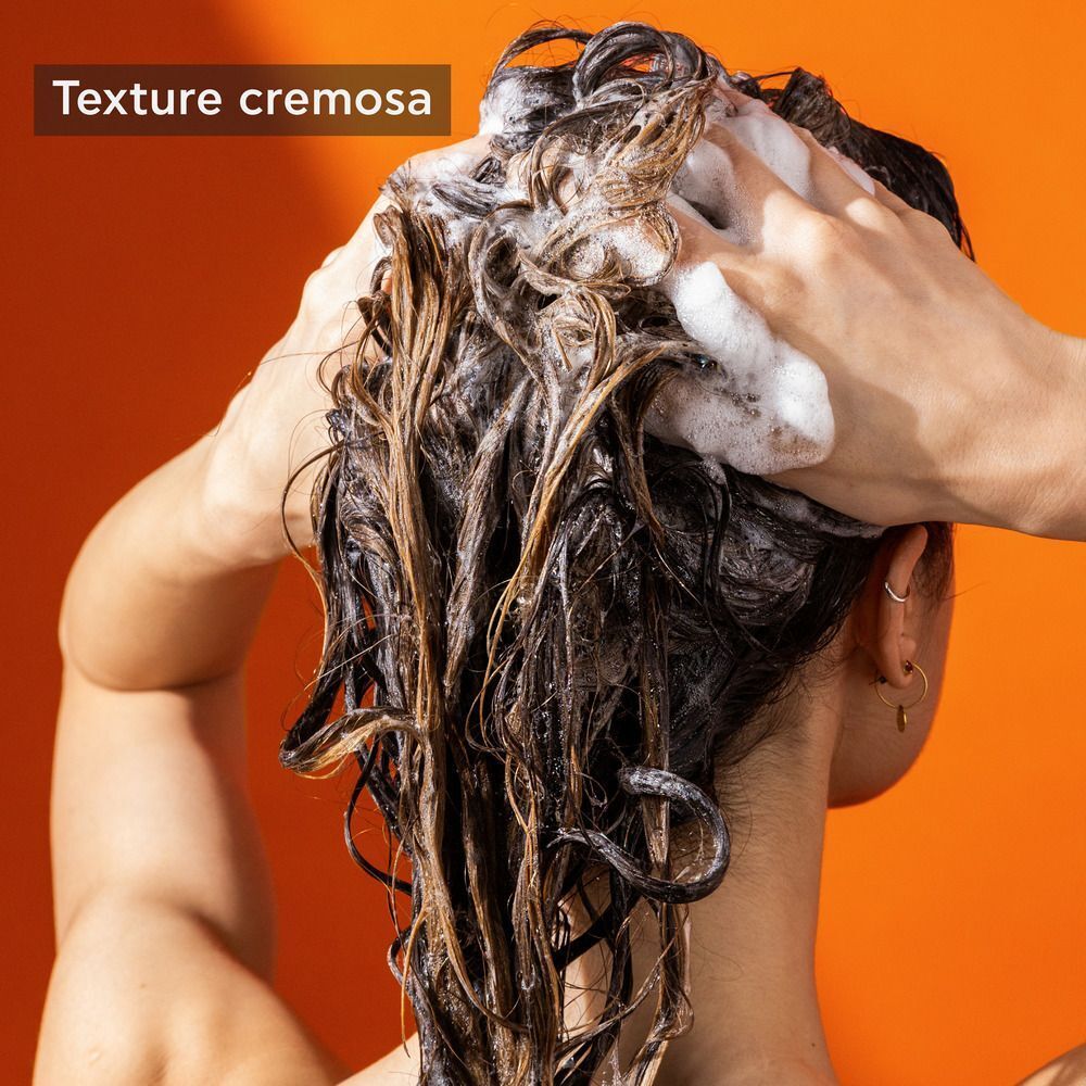 Texture cremosa dello shampoo APIVITA SHINE durante il lavaggio dei capelli.