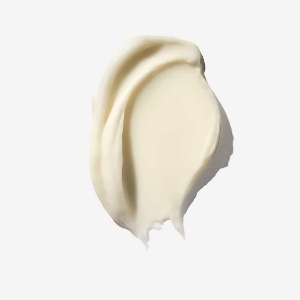 Una maschera per capelli cremosa, giallo pallido, a forma ondulata su sfondo bianco.