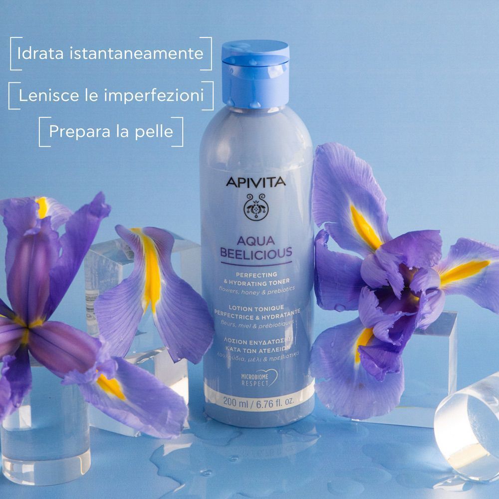 Tonico Apivita Aqua Beelicious con iris e oggetti in vetro.