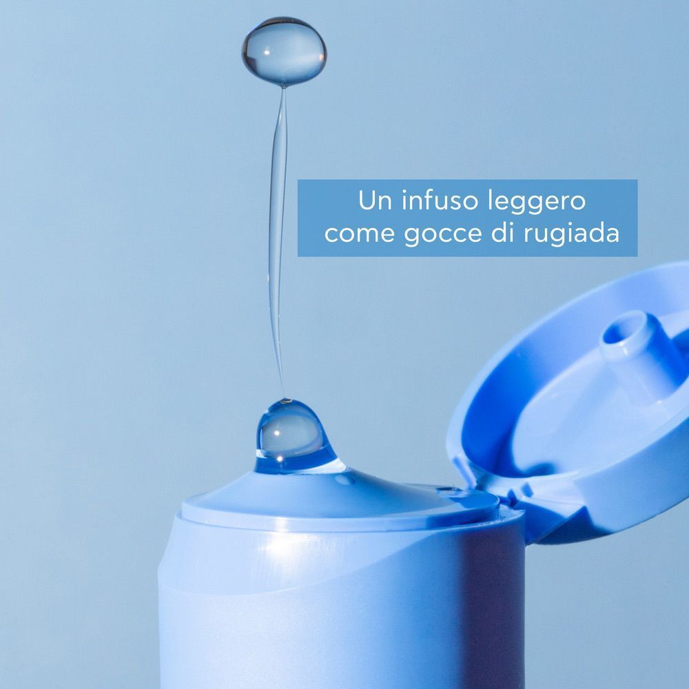 Gocce di tonico Apivita Aqua Beelicious che cadono dal collo aperto.