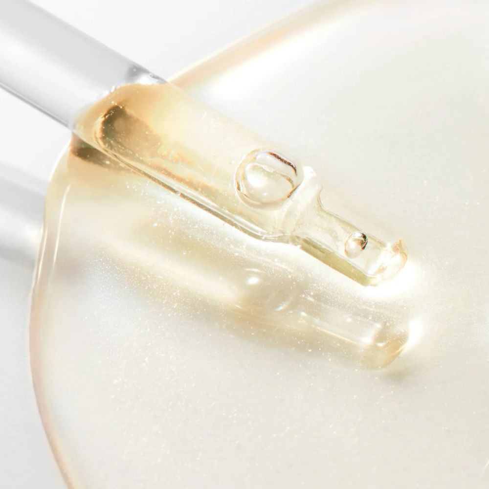 Goccia di siero Nuxe su una superficie liscia e scintillante.