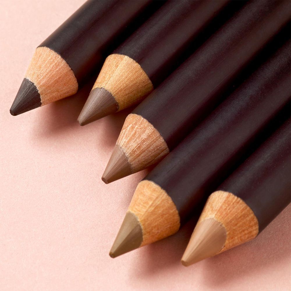Primo piano di quattro matite per sopracciglia Astra Expert in diverse tonalità di marrone.