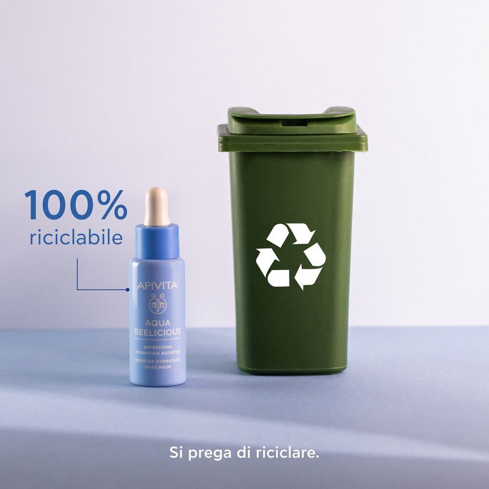 Apivita Aqua Beelicious Booster accanto a un bidone di riciclaggio verde, 100% riciclabile.
