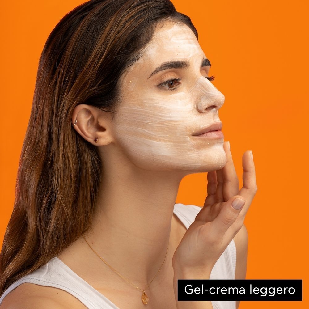 Donna che applica una maschera viso APIVITA EXPRESS BEAUTY Arancia.